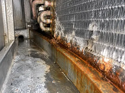 corroded lower rows above an AHU drain pan