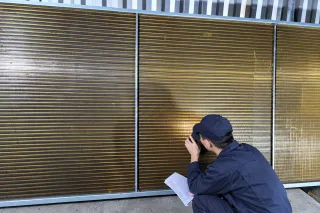 inspector checking a coated coil against the specification sheet